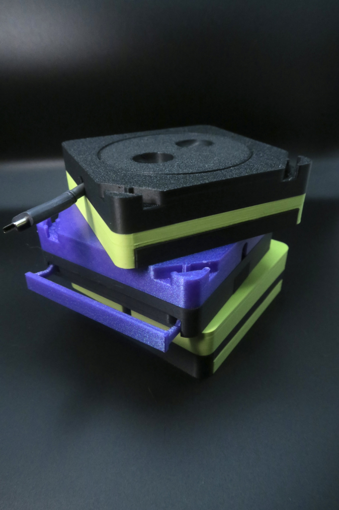 CORDGANIZER phone stand and cable organizer - stacked color variants (black, green, purple)
